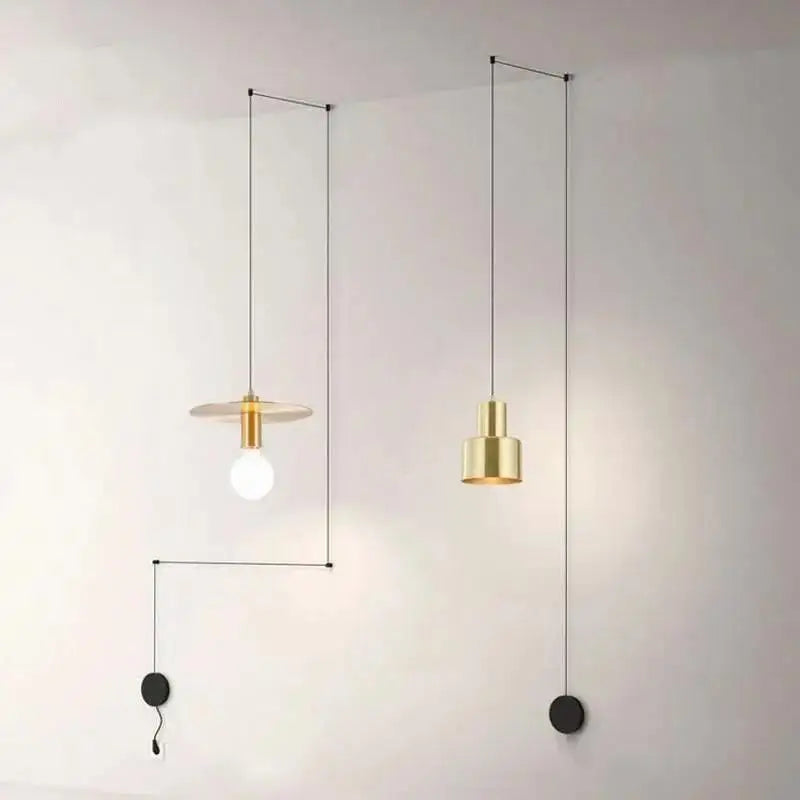 Two minimalist brass pendant lights with geometric designs hanging from black cords in decorbites™ modern diy pendant light