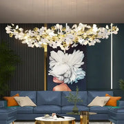 DecorBites™ modern ginkgo leaf LED chandelier with white floral and gold accents for elegant dining room lighting above blue sofa