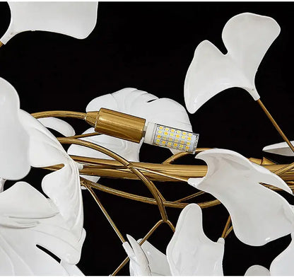 White ceramic ginkgo leaf LED chandelier with gold-toned metal frame for modern dining room lighting by DecorBites™