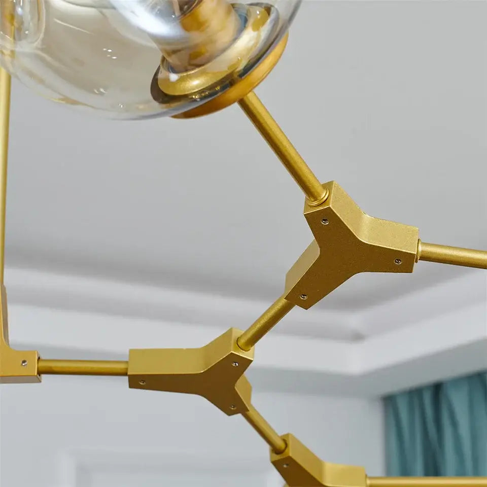 Gold-toned DecorBites™ modern glass ball pendant chandelier with black gold geometric frame and clear Nordic glass ball fixtures
