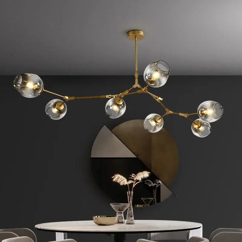 Gold-toned DecorBites™ modern glass ball pendant chandelier with clear globe shades in black gold finish