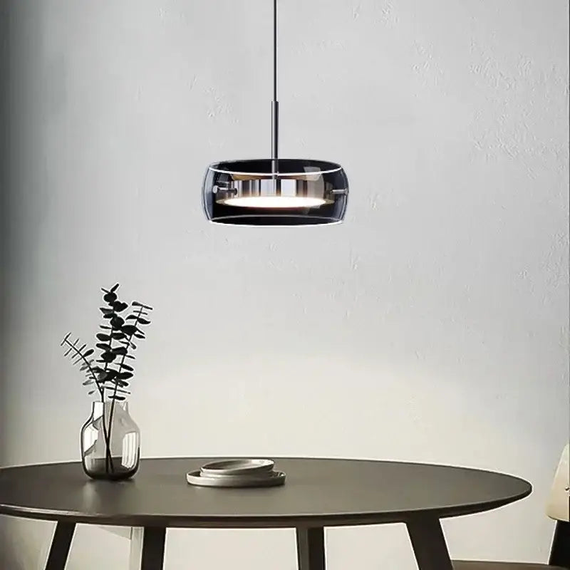 Modern black glass pendant light with sleek circular design and metallic accents for dining table pendant use