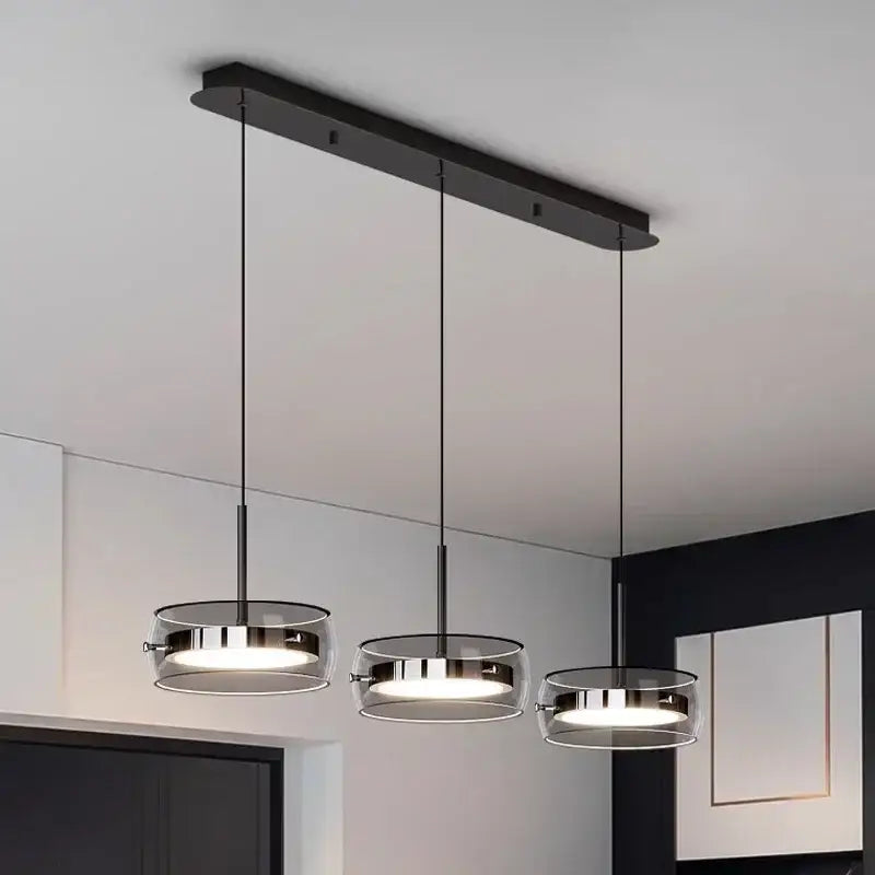 Modern black metal pendant light fixture with three circular glass shades and chrome accents for dining table pendant use