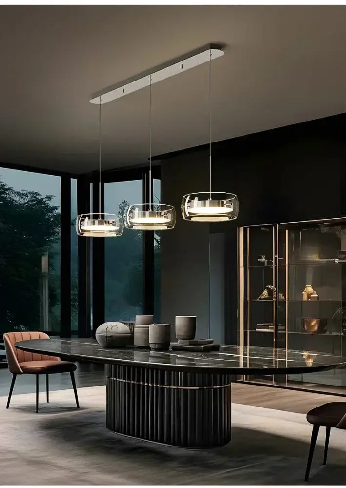 DecorBites™ modern glass dining table pendant light with clear glass shades and sleek metallic frames above dark marble table