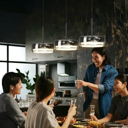 Three modern circular chrome pendant lights with frosted glass shades for dining table pendant illumination