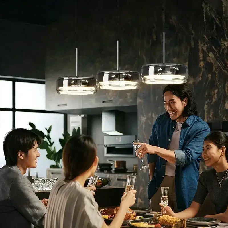 Three modern circular chrome pendant lights with frosted glass shades for dining table pendant illumination