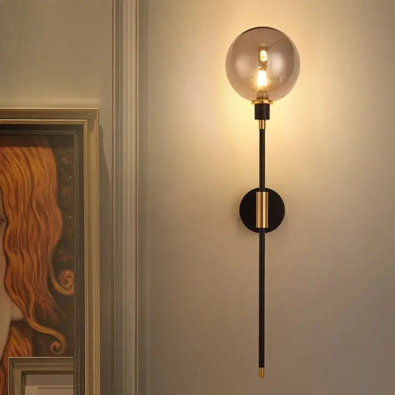 DecorBites modern glass wall sconce with smoked glass globe black metal rod and gold-toned accents for stylish lighting