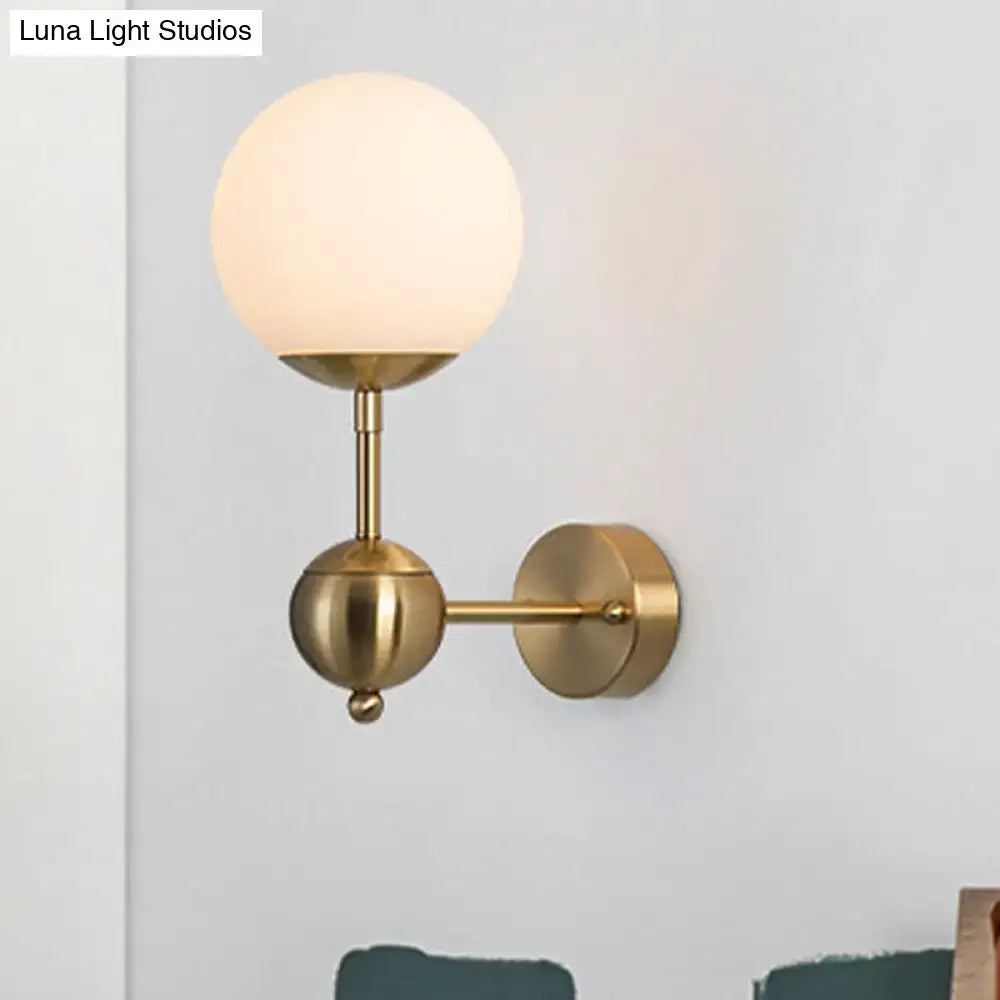 Modern brass spherical globe wall sconce with white glass frosted shade direct wired led light for bathroom use