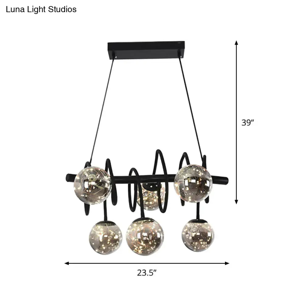 Black metal chandelier with five smoke gray glass shades suspended from a horizontal bar for dining room lighting