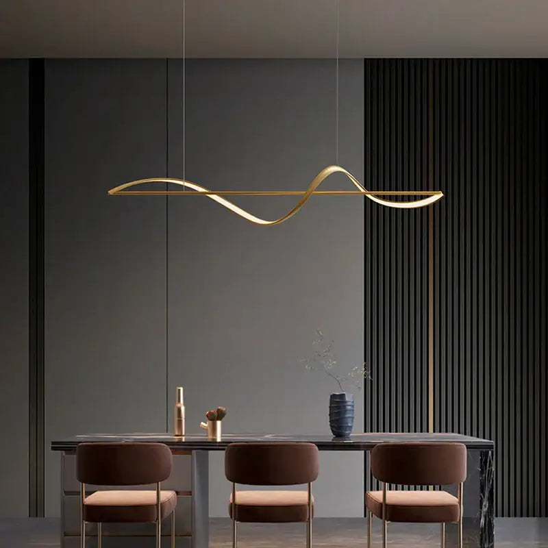 Gold-colored sleek curved pendant light with minimalist design for dining or bedroom in decorbites modern led chandeliers