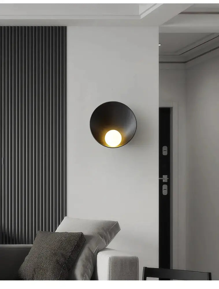 Black matte-finished decorbites™ modern led wall light with circular bowl-shaped design emitting warm light