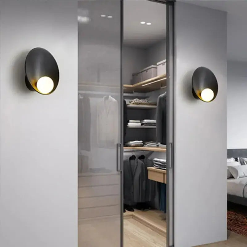 Black oval wall sconce with warm glowing circular led light from decorbites modern led wall lights collection