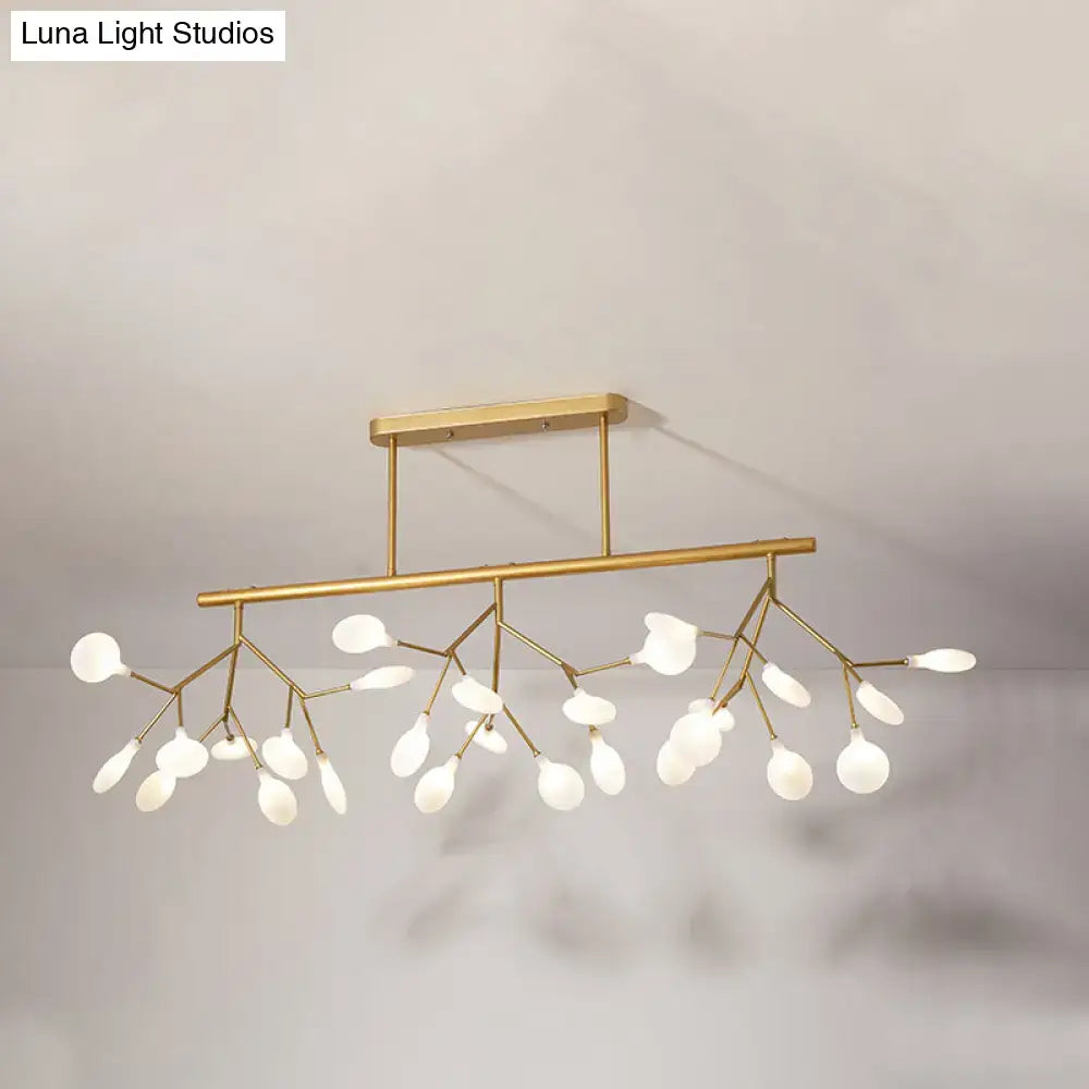 Gold-toned modern metal linear island chandelier with delicate branch-like arms and frosted glass globe lights