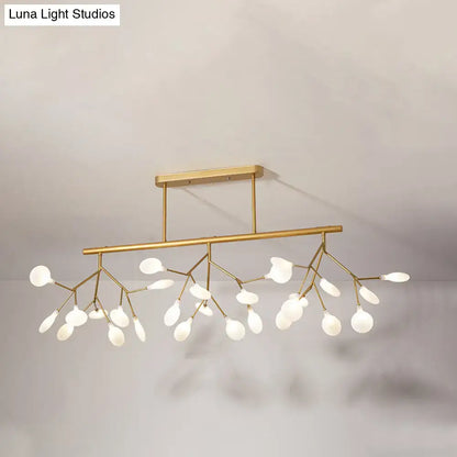 Gold-toned modern metal linear island chandelier with delicate branch-like arms and frosted glass globe lights