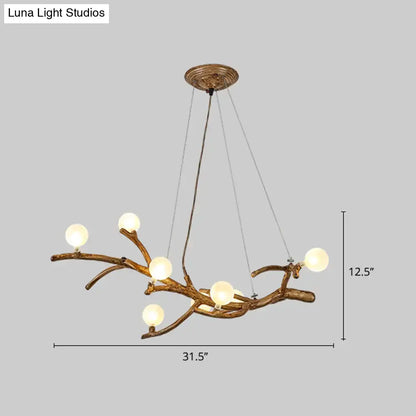 Antique brass metal tree branch chandelier with six frosted glass globes for tree branch island lighting by DecorBites