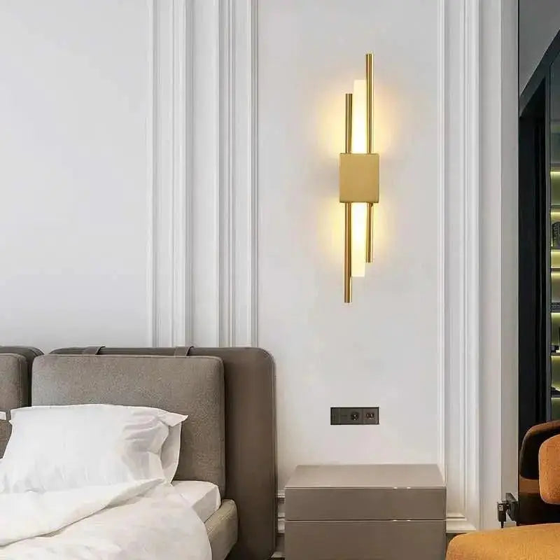 Gold-toned DecorBites™ modern metal wall lamp with vertical cylindrical rods and a central rectangular panel