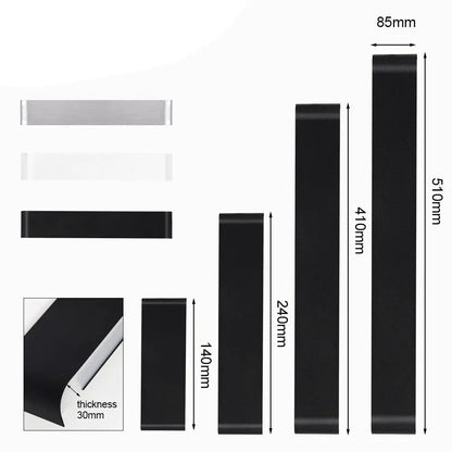 Black rubber resistance bands in various lengths and thicknesses with one 85mm wide next to modern metal wall sconces decorbites
