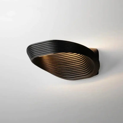 DecorBites™ modern minimalistic wall sconce in black with sleek curved design and concentric ridged texture