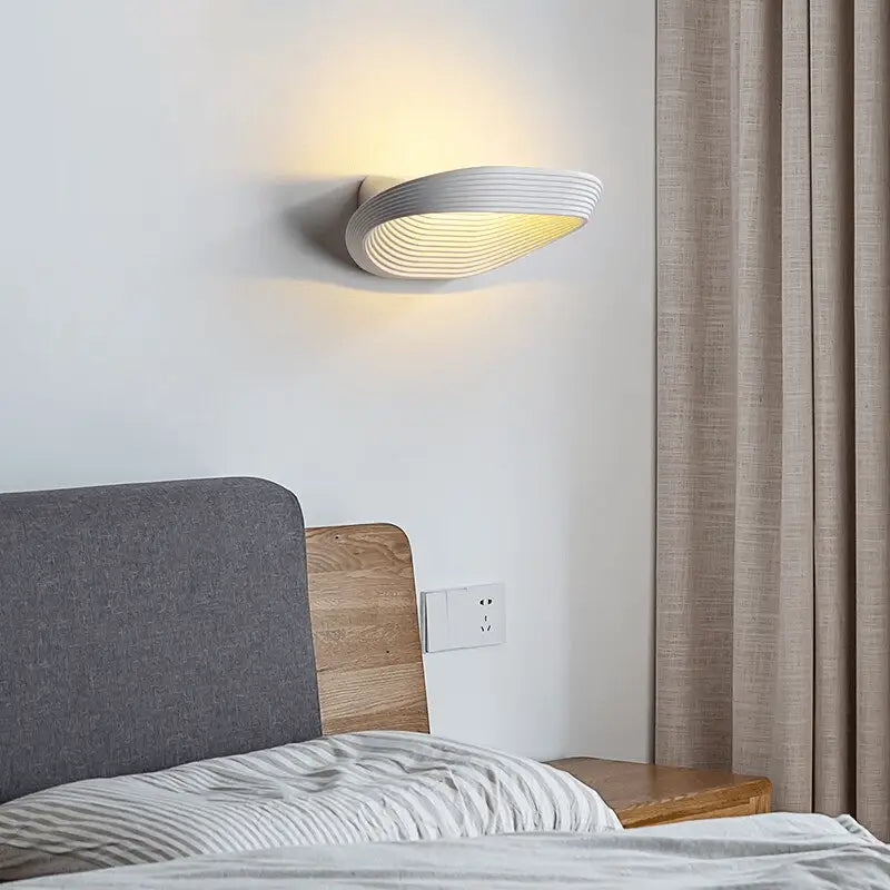 Modern white decorbites™ wall sconce with sleek curved design and subtle horizontal ridges for minimalistic wall decor