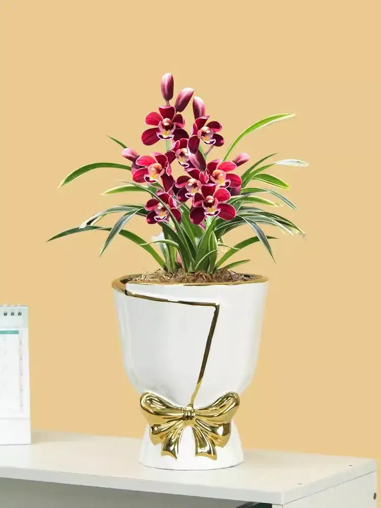 A modern nordic white ceramic vase with gold accents and red orchids for stylish home decor by DecorBites