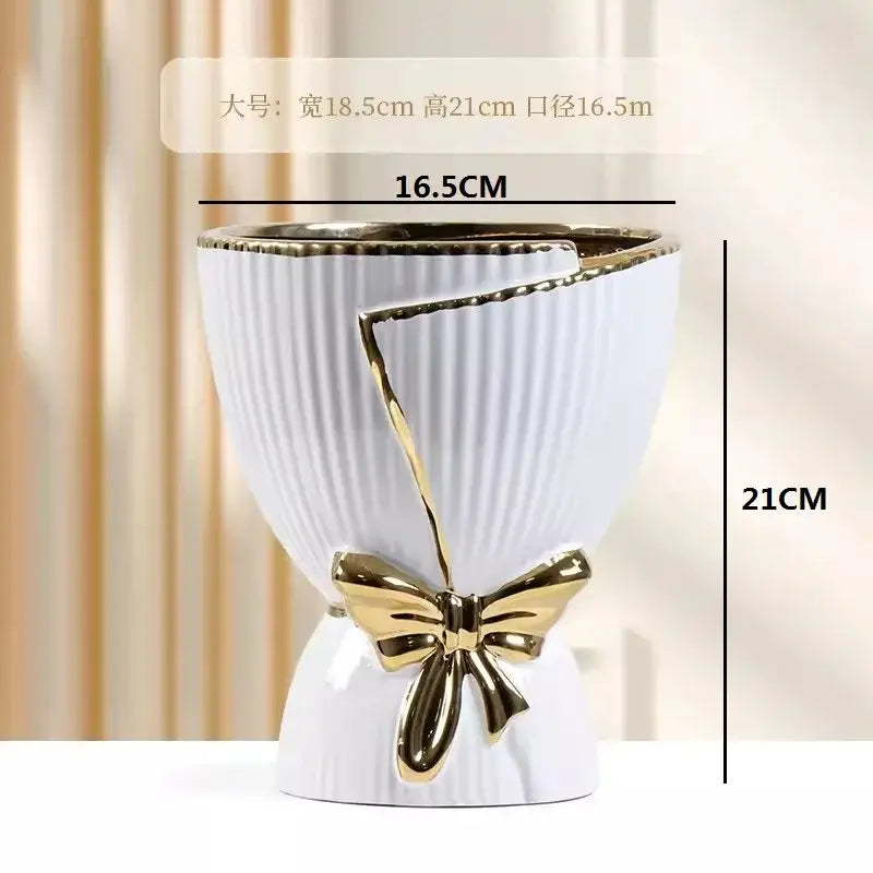 White ceramic vase with gold ribbed texture and decorative gold bow for modern nordic home decor by DecorBites