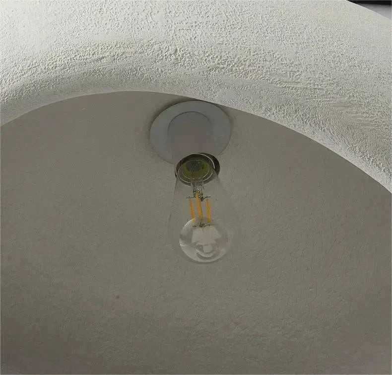 Clear glass led bulb with visible filament in white fixture of decorbites modern nordic chandelier emitting warm light