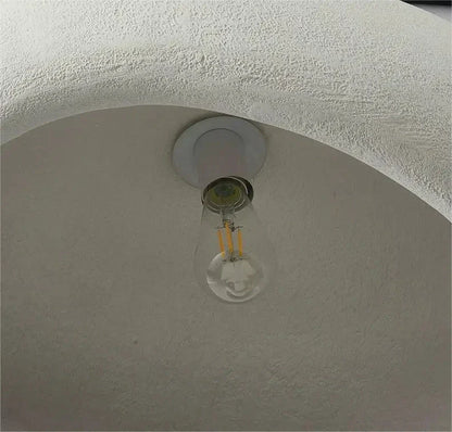 Clear glass led bulb with visible filament in white fixture of decorbites modern nordic chandelier emitting warm light