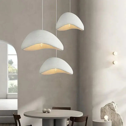 Three white shell-shaped pendant lights with warm light turn in the modern nordic chandelier for home and dining