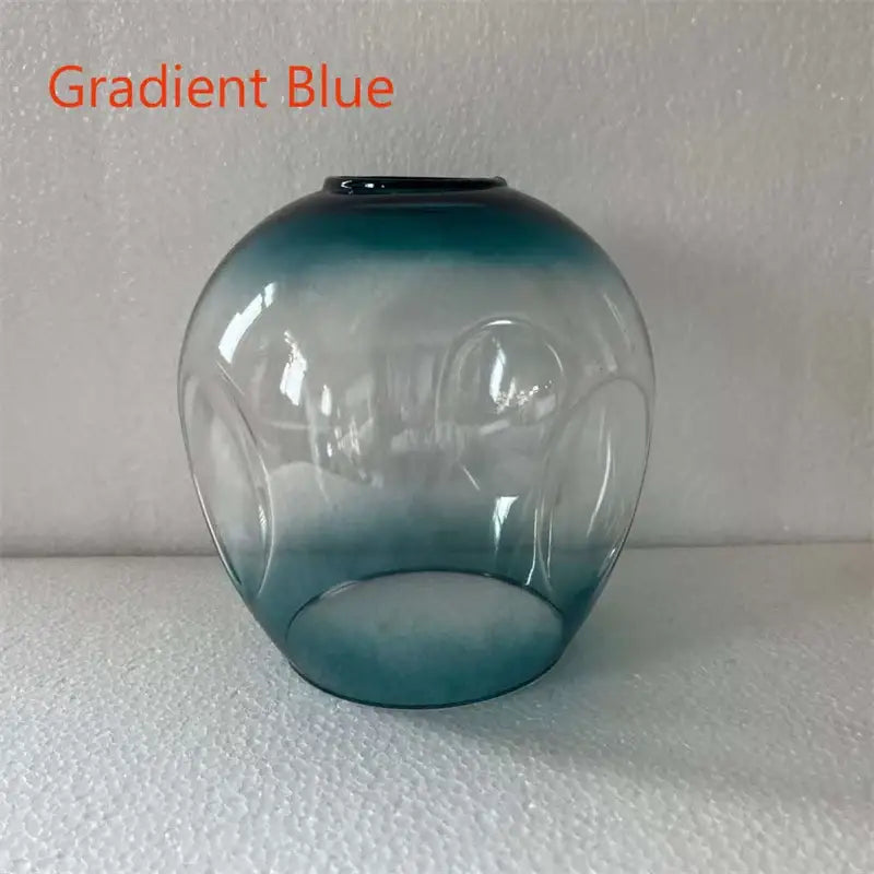 Gradient blue glass vase with embossed circular patterns complements modern nordic glass chandeliers decor