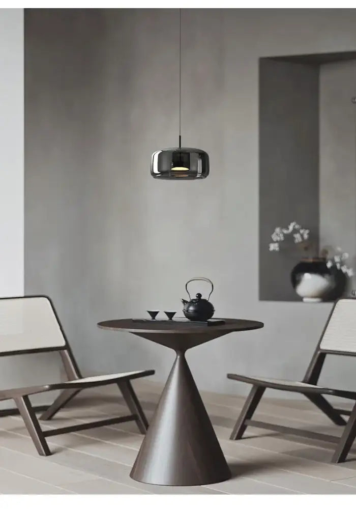 Dark bronze conical table paired with a modern nordic glass pendant lamp featuring a minimalist glass restaurant pendant design