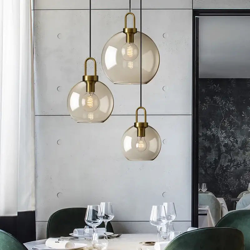 Three smoked glass pendant lights with brass-finished fixtures by DecorBites™ for modern kitchen and restaurant use