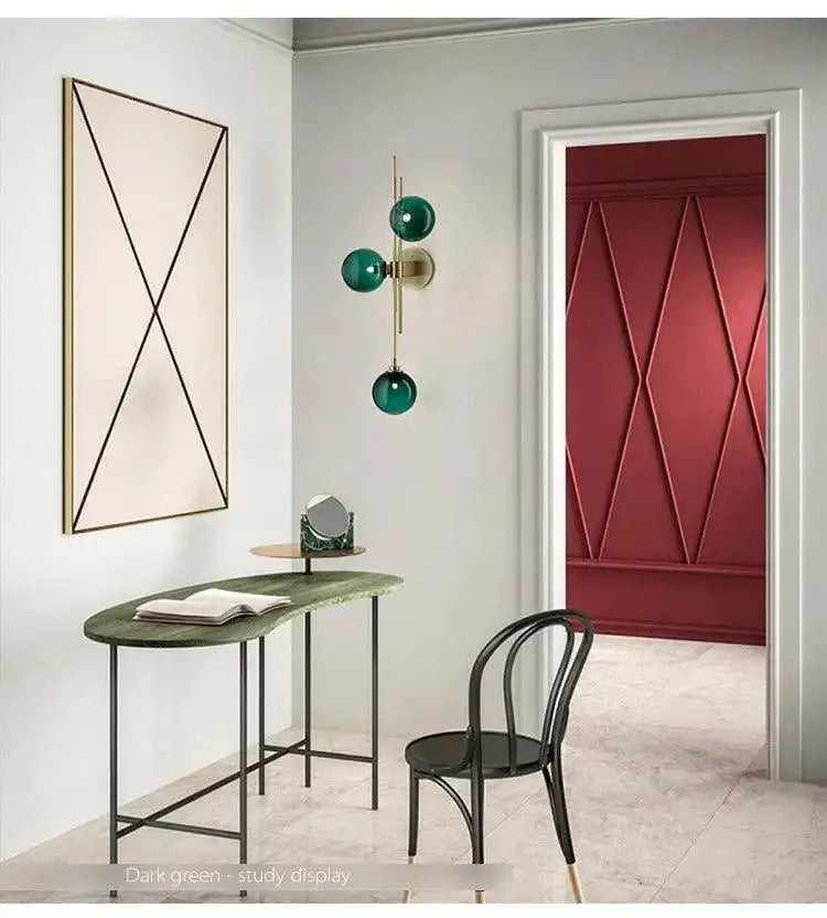 Dark green marble study display table with slender black metal legs paired with decorbites™ modern nordic glass wall sconce with green glass shade
