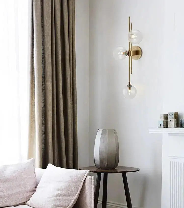 Decorbites modern nordic gold-toned wall sconce with three clear glass globe bulbs for elegant lighting decor