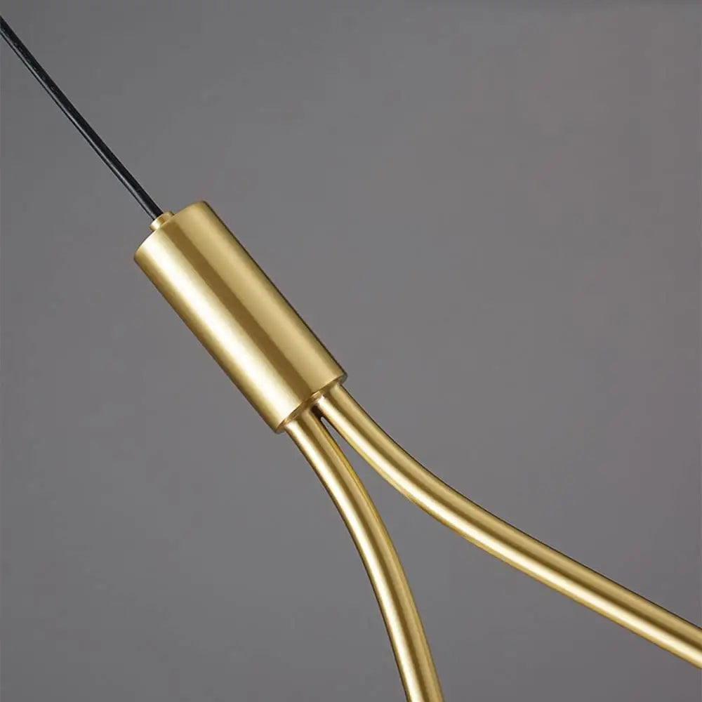 Gold-toned cylindrical metal connector with curved brass rods of decorbites modern nordic pendant light in gold
