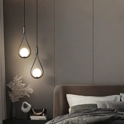 Two DecorBites™ modern nordic pendant lights with teardrop glass shades and black metal frames hanging against dark wall