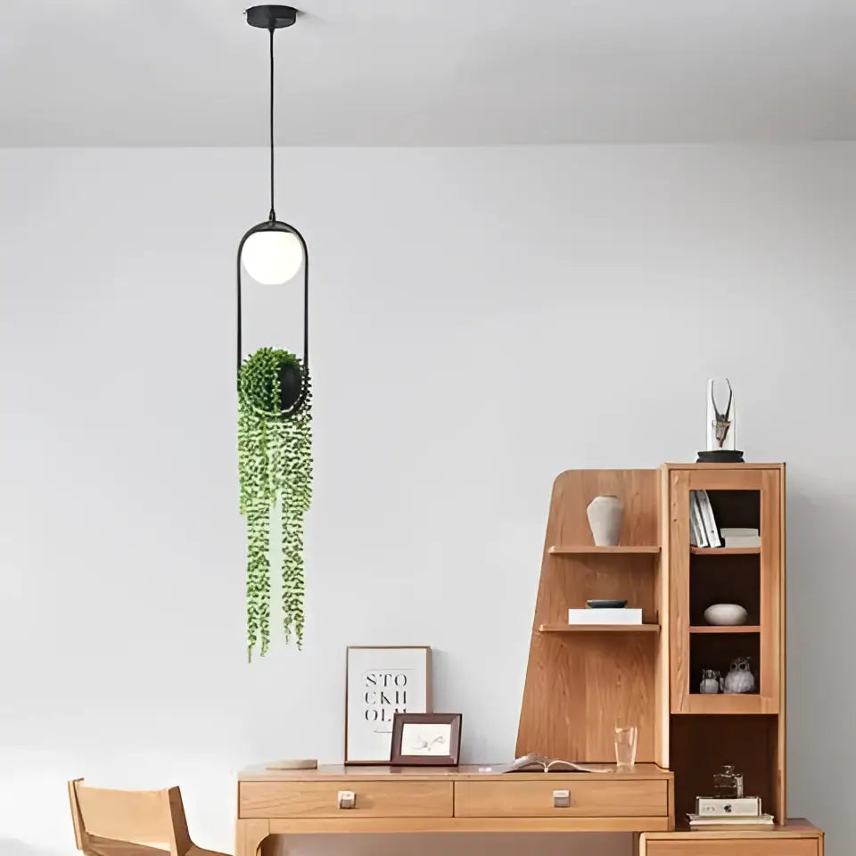 Black metal modern planter pendant light with white globe bulb and hanging green ivy in a circular planter by DecorBites™