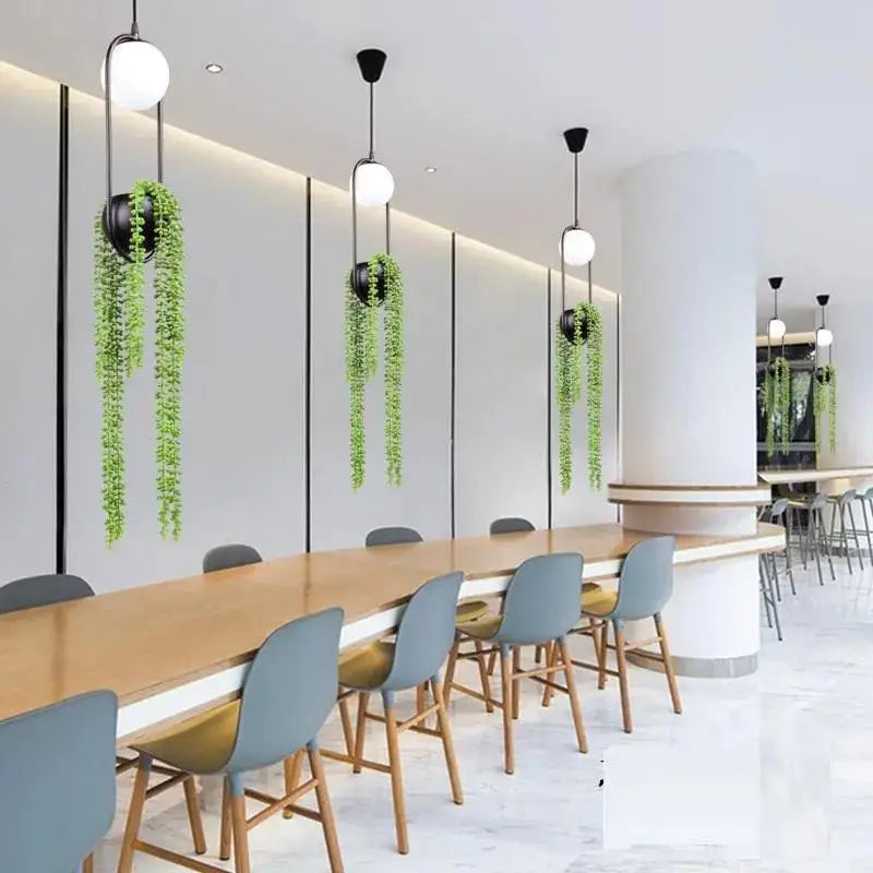 Decorbites™ modern planter pendant lighting with spherical white bulbs black fixtures and hanging green plants in black pots