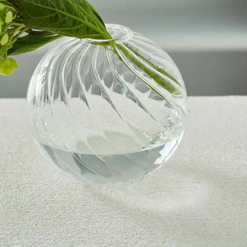 DecorBites™ modern transparent glass spherical vase with vertical ribbed texture holding green hydrangea stems in water