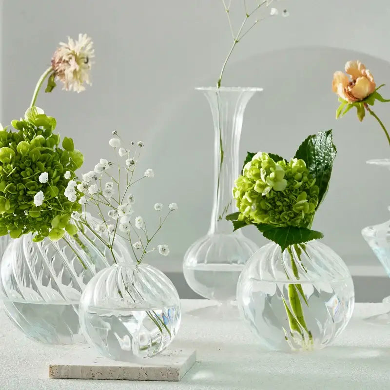 Decorbites modern transparent glass vases set with ribbed texture holding green hydrangeas and white babys breath
