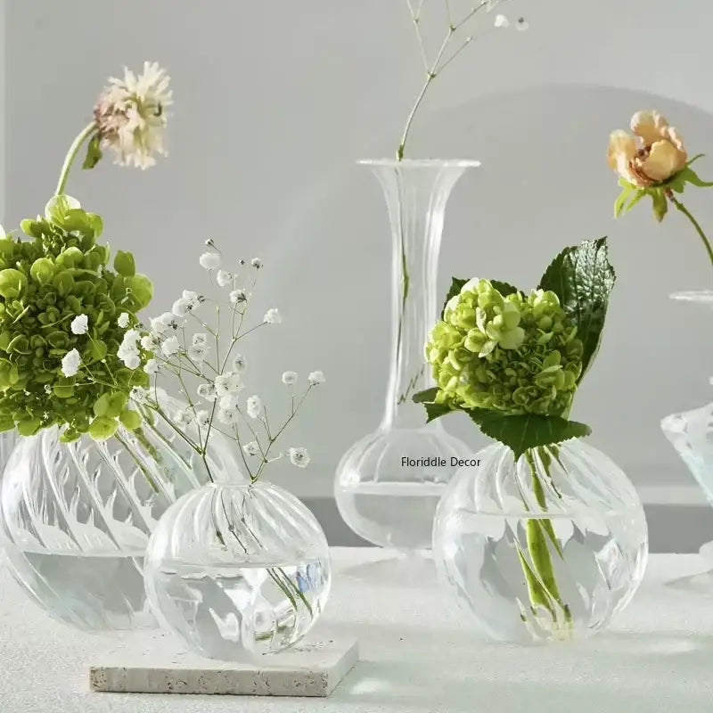 DecorBites™ modern transparent glass vases set with textured ribbed surfaces holding green hydrangeas and white baby’s breath