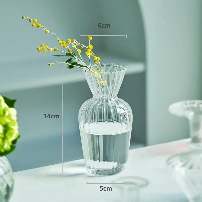 DecorBites™ modern transparent glass vase with vertical ridges and fluted rim holding yellow flowers in water