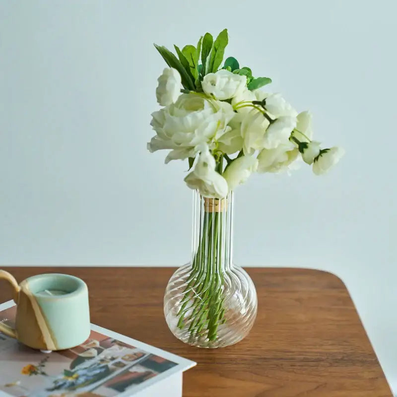 DecorBites™ modern transparent glass vase with vertical ridges holding white artificial flowers to decorate root spaces