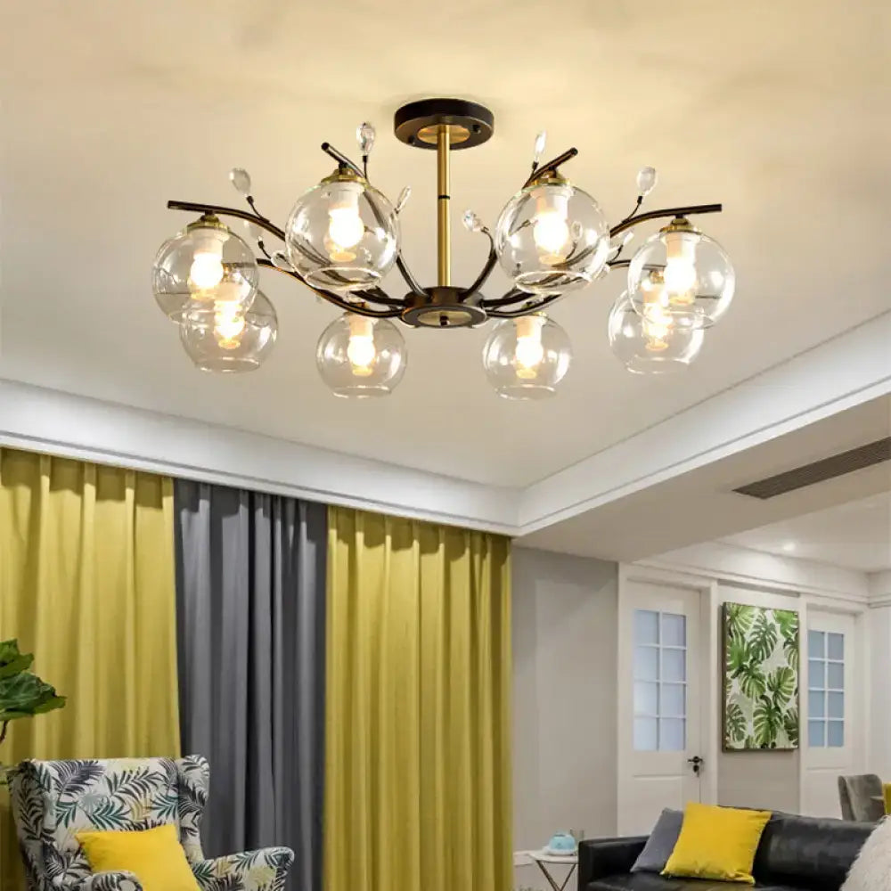 DecorBites modernist ceiling light with brass frame black arms and cream clear glass globe shades emitting warm light