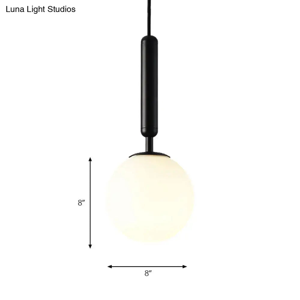 Black cylindrical pendant light with an 8-inch white glass globe and gold finish by decorbites adjustable fixture sizes