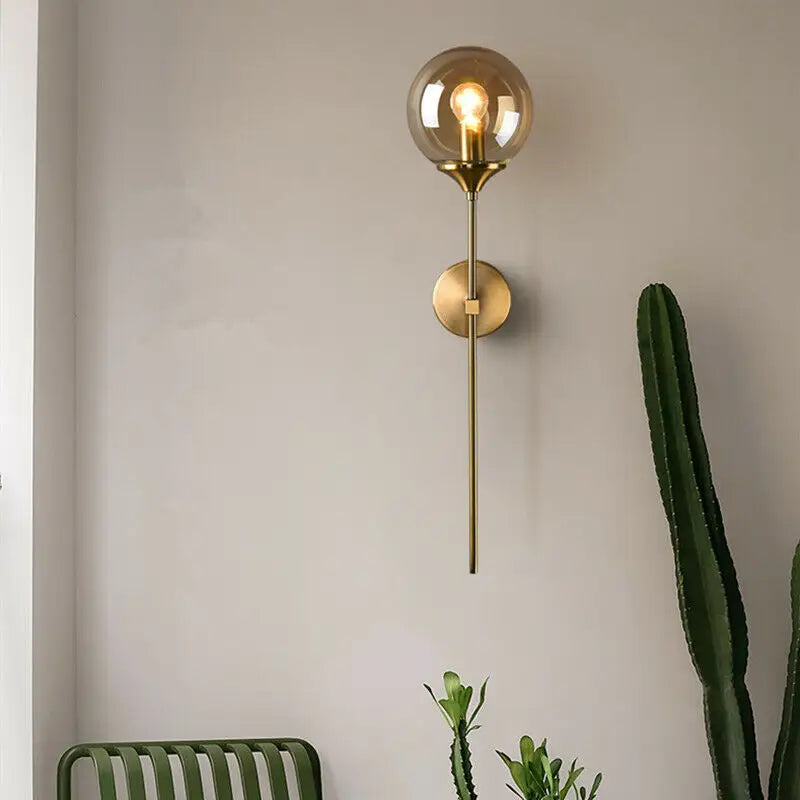 Brass-finished DecorBites Moroccan glass wall sconce with smoked glass globe and exposed filament bulb