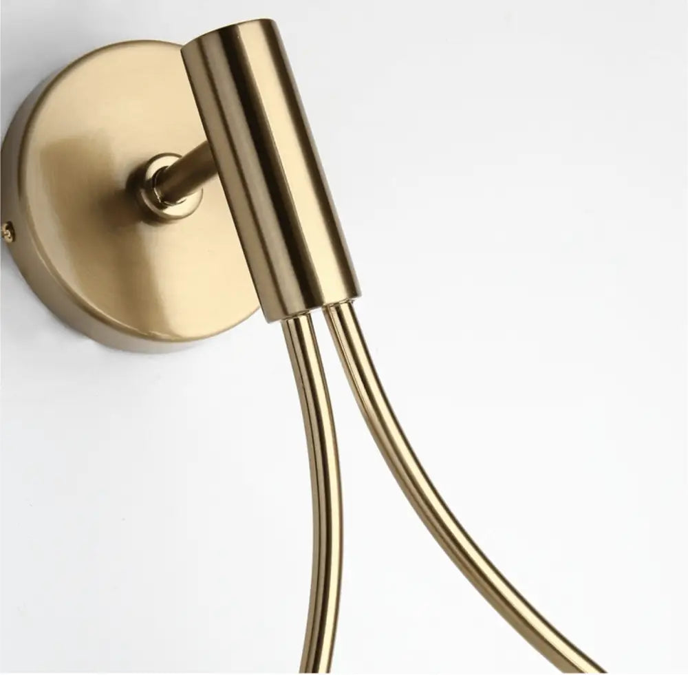 Brass-finished wall-mounted towel rack with circular base and two slender rods complements modern nordic wall lamp designs