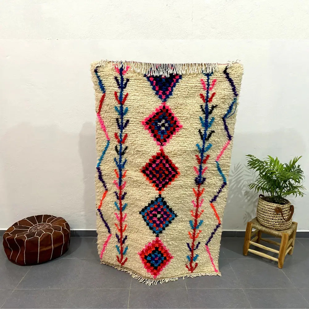 Beige moroccan handmade azilal rug with vibrant pink blue and red geometric patterns and fringed edges decorbites 1.5m x 1m