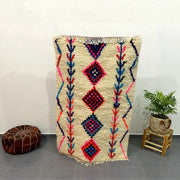 Beige moroccan handmade azilal rug with vibrant pink blue and red geometric patterns and fringed edges decorbites 1.5m x 1m