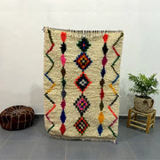 Vibrant cream-colored moroccan handmade azilal rug with geometric diamond and zigzag motifs 1.5m x 1m by DecorBites