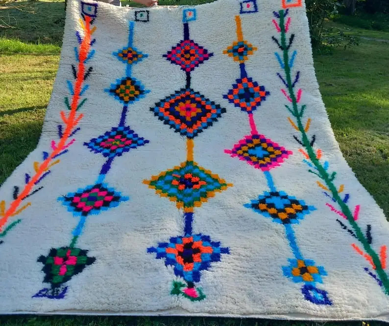 A vibrant fluffy white moroccan handmade azilal rug with bold geometric patterns in orange blue pink and green 2.5m x 1.5m